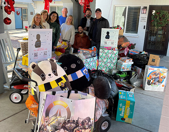 Group stands with donated gifts.