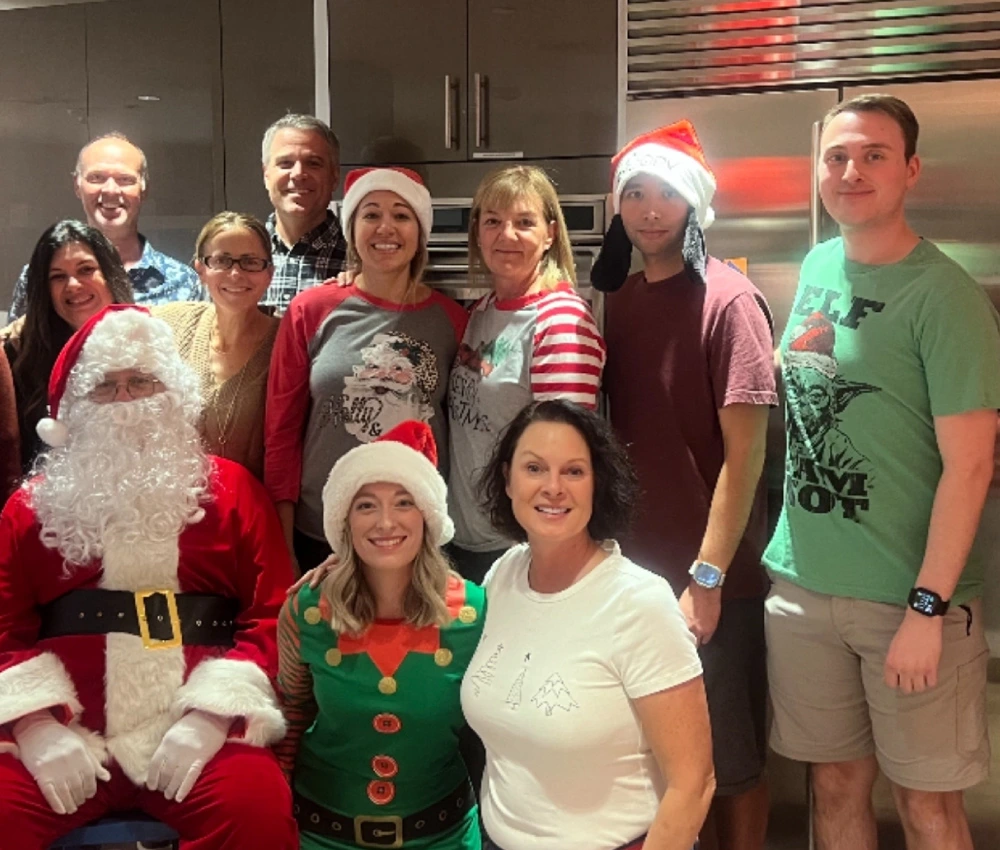 group of volunteers gathered in the kitchen with Santa Claus
