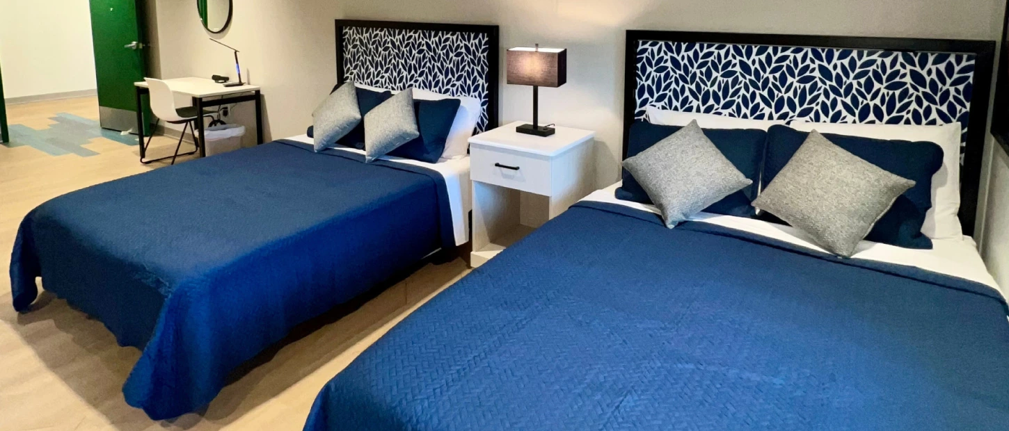 a room with double queen beds ready for a family