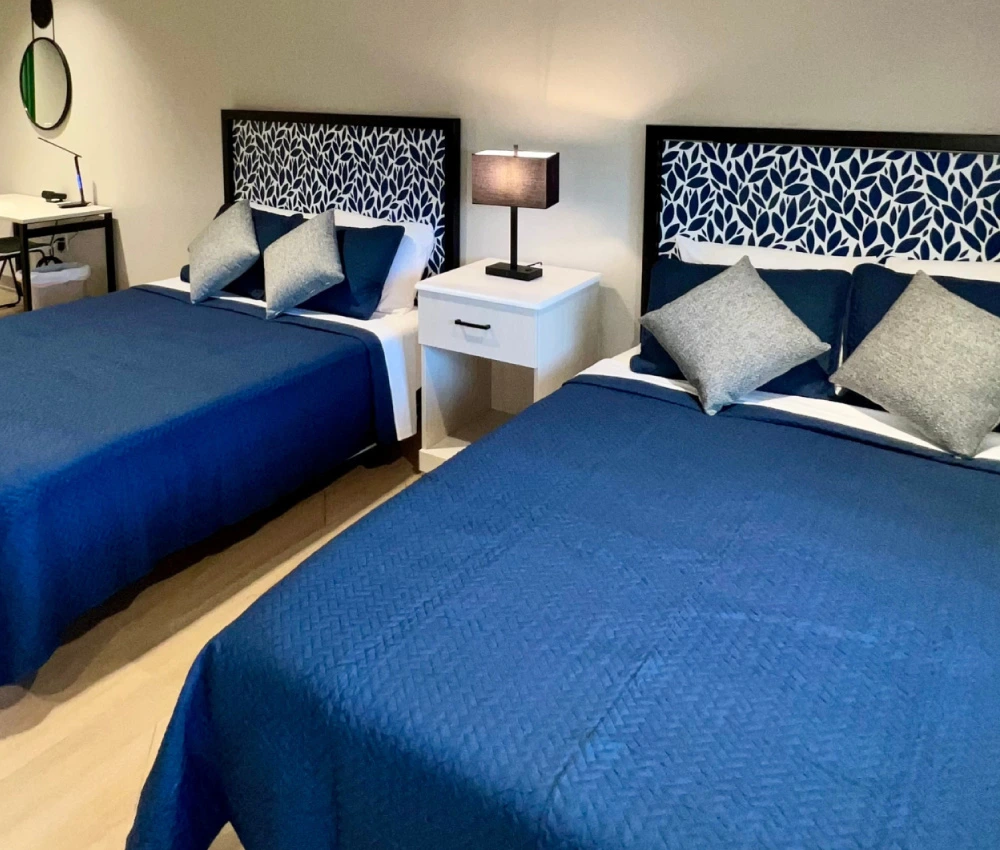 a room with double queen beds ready for a family