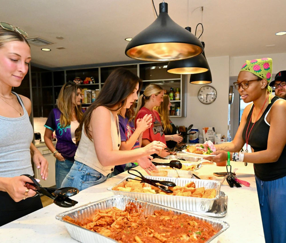 volunteer group serving dinner to houseguests