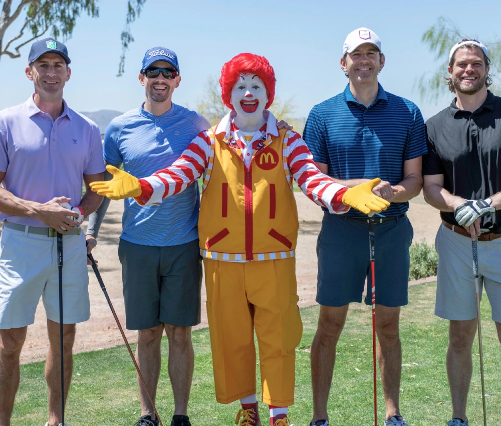 group of golfers with Ronald McDonald in the middle for a group photo