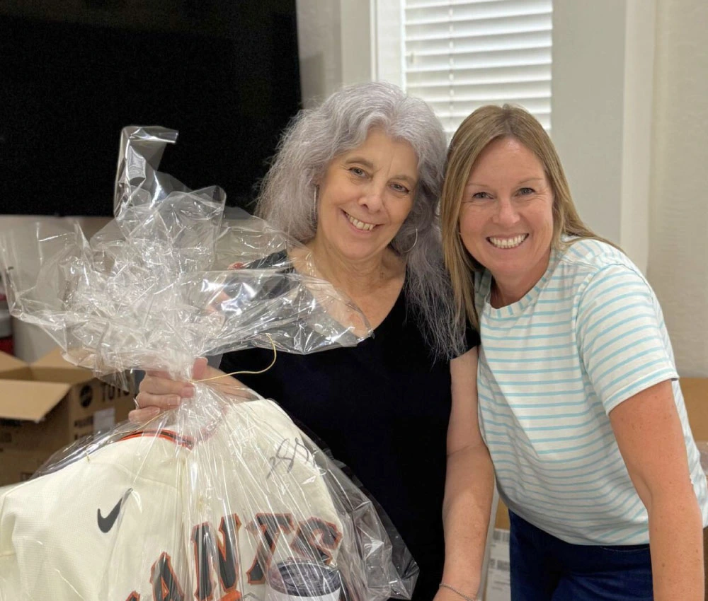 two volunteers holding up a raffle gift