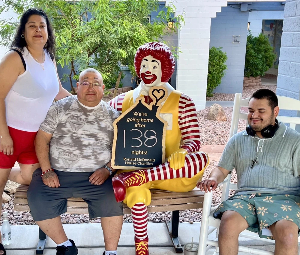 Israel and his family gathered around a statue of Ronald McDonald