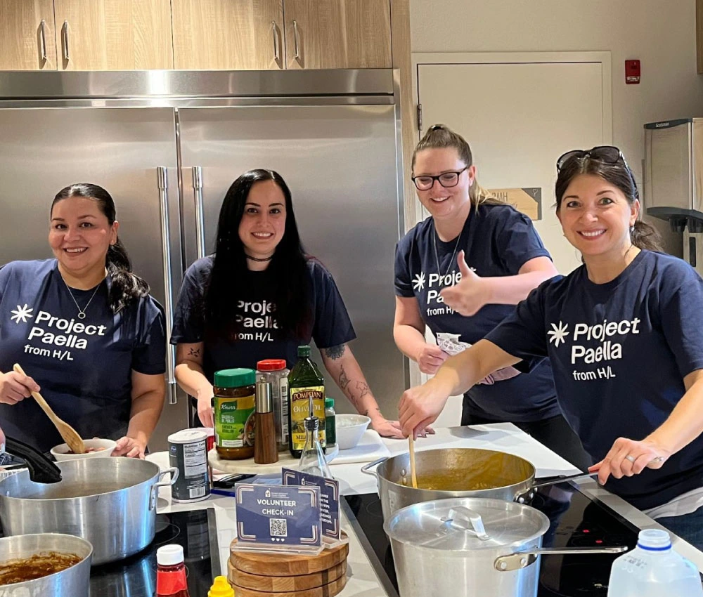 volunteer group in matching shirts preparing a meal for houseguests