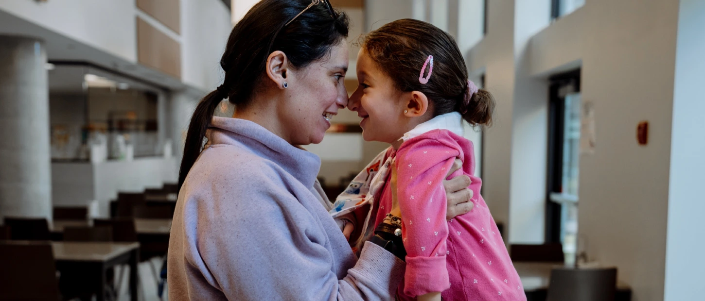 mother lifting daughter closely with faces touching