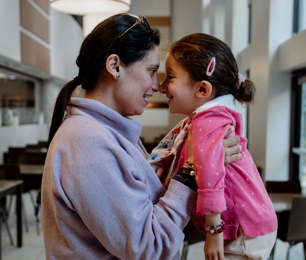 mother lifting daughter closely with faces touching