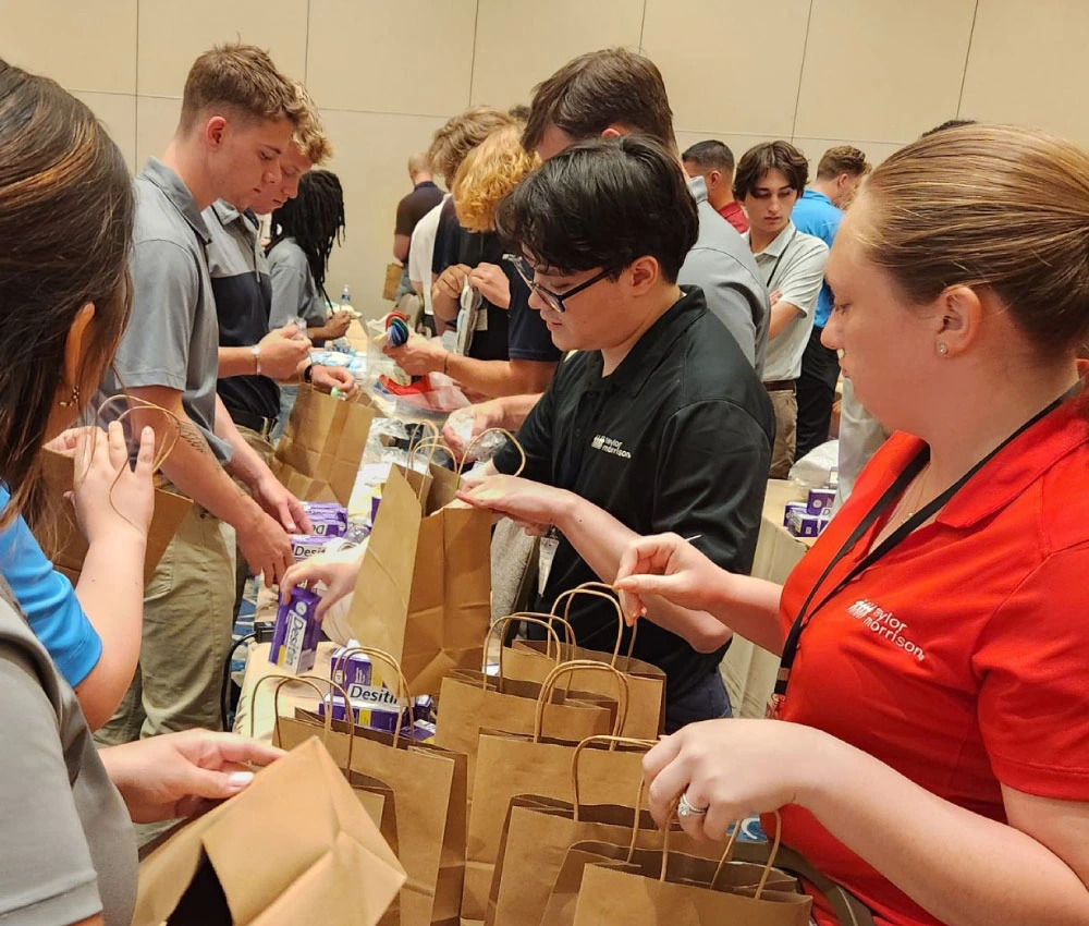 group of high school students gathered to create giveaway bags for houseguests
