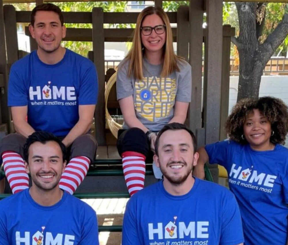 members of the red shoe society wearing matching shirts at event