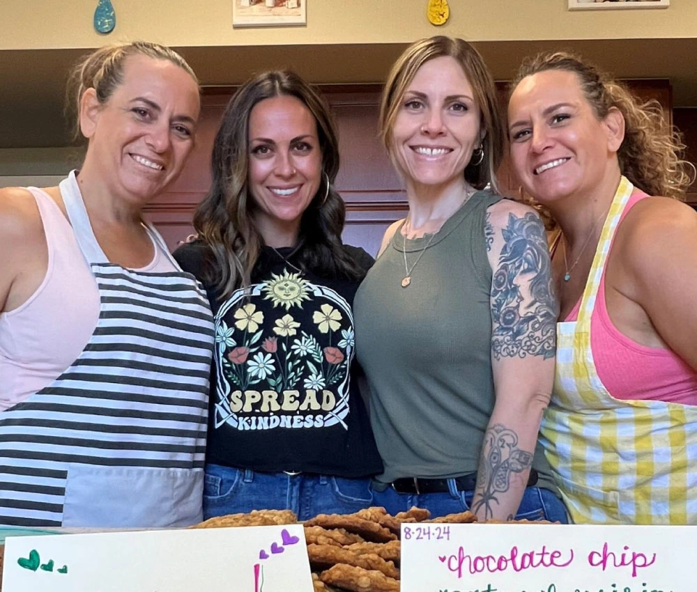 group of volunteer bakers with a collection of fresh baked cookies